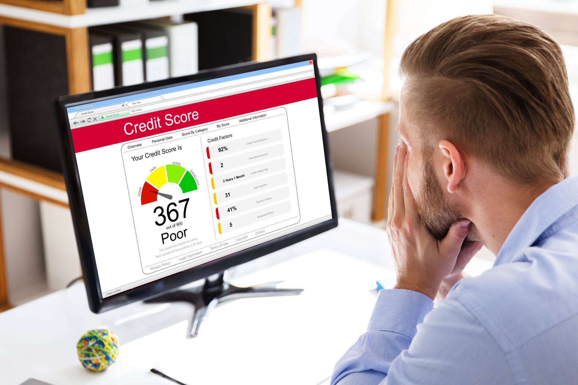 Man sitting at a computer looking disappointed at his low credit score.