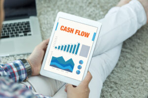 businessman holding screen showing a positive cash flow chart